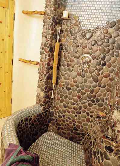 In the bathroom, Tom and Flame worked side by side with a contractor, adorning a free-form bathtub with tiles and stones collected from the property and during their travels in San Diego, Santa Fe, Mexico, and Greece. They cemented crystals into the mix to act as towel and robe holders.